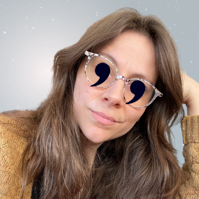 Image shows a headshot of Toni Oberto, a white person with long brown hair, and glasses. The image shows Toni with commas for eyes